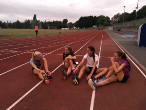 girls sitting laughing on a running track
