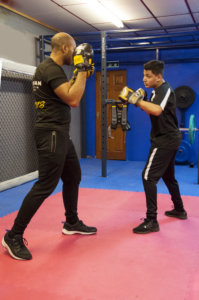 men sparring with boxing gloves and pads