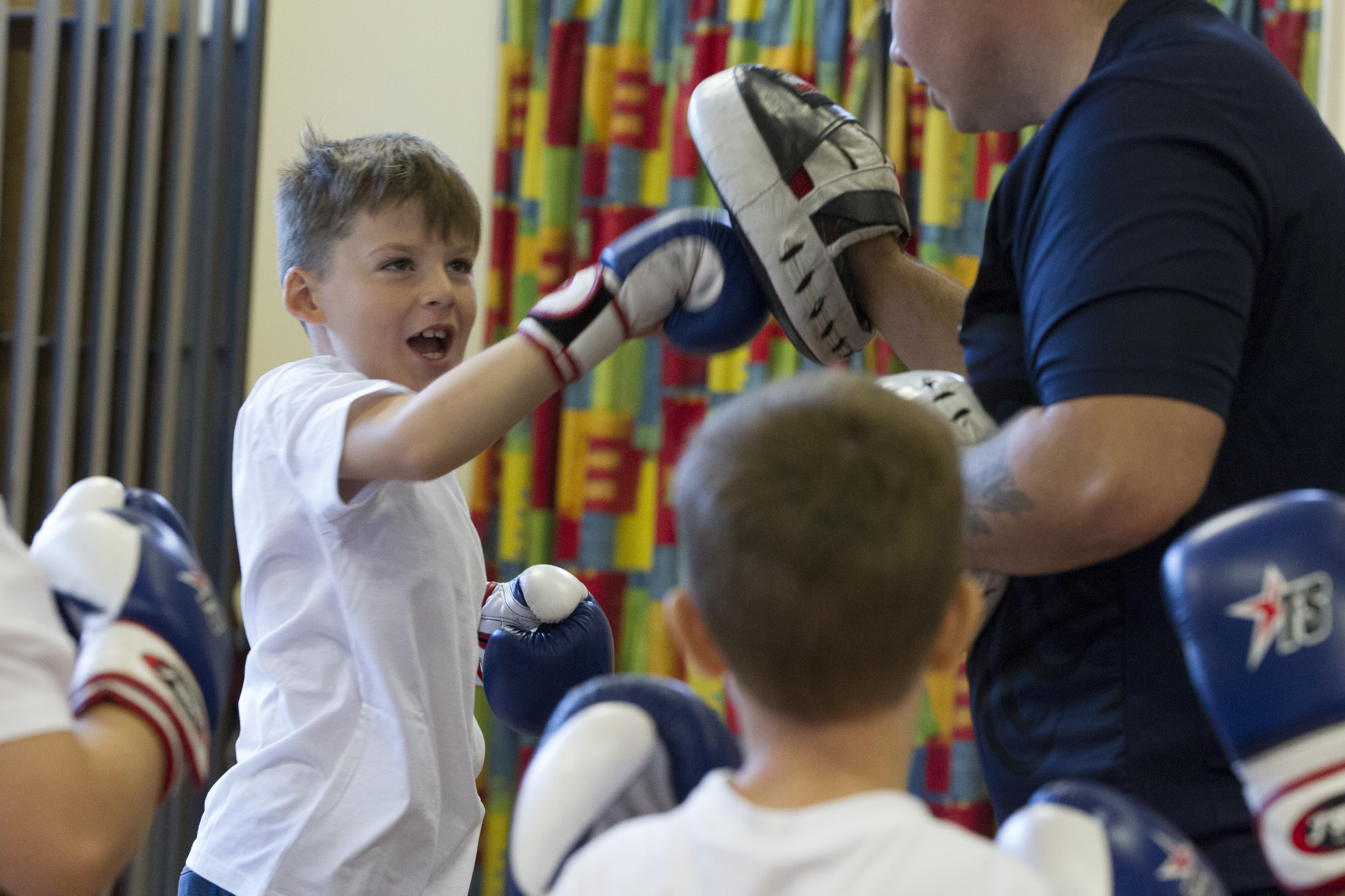 young boys enjoying using boxing gloves and pads