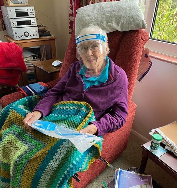 Older lady sat in chair reading booklet