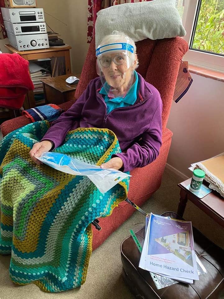 Older lady sat in chair reading booklet