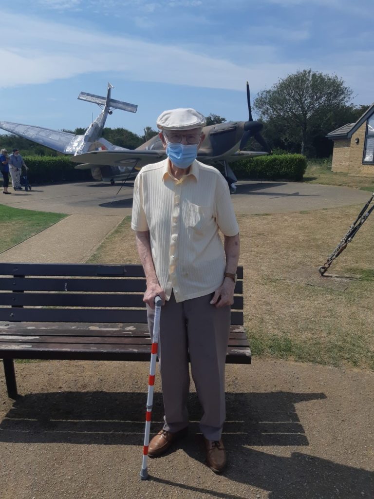 Older man standing by bench