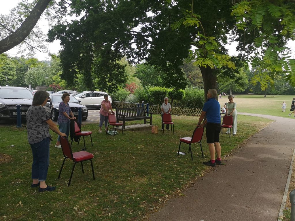 group of people using chairs for chair yoga