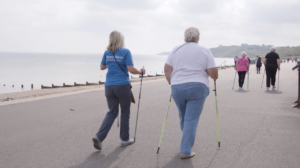 two ladies walking with nordic poles on coast