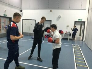 young boys boxing with a coach from olympia boxing
