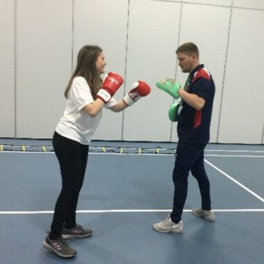 girl boxing with a trainer