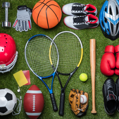 A variety of equipment from different sports lying on the floor