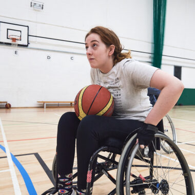 person in wheelchair playing basketball