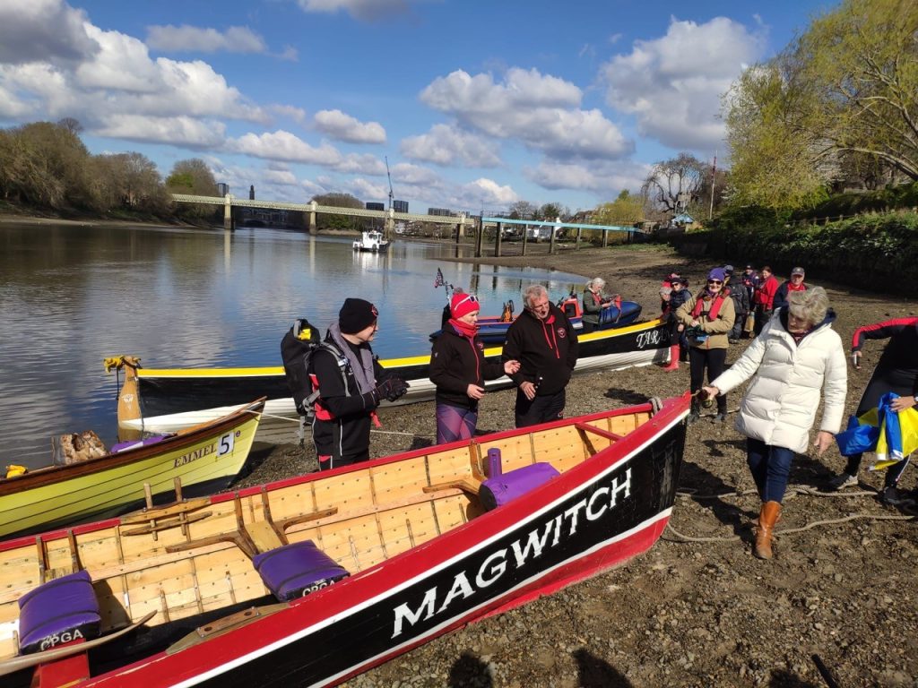 people standing by gig rowing boats