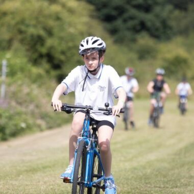 young person cycling on grass