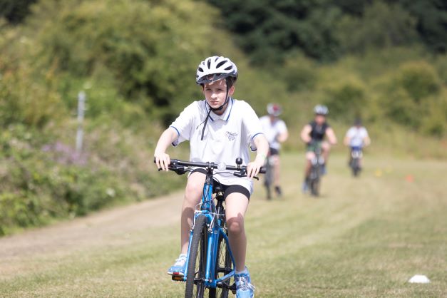 young person cycling on grass