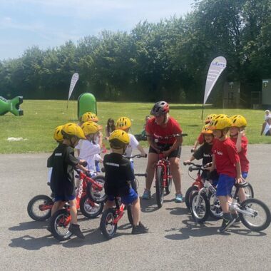 children on bikes listening to a teacher