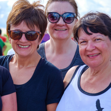four smiling women looking hot and sweaty outside