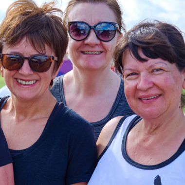 four smiling women looking hot and sweaty outside