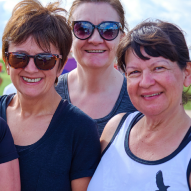 four smiling women looking hot and sweaty outside