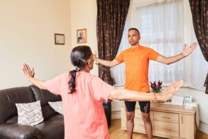 two people at home standing up doing arm exercises