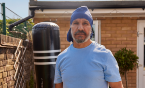 man stood in garden next to boxing bag