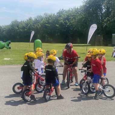 children on bikes listening to a teacher