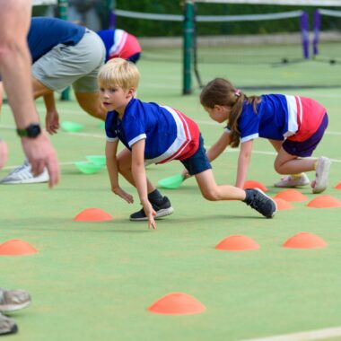 young person playing a cone game in a sports hall