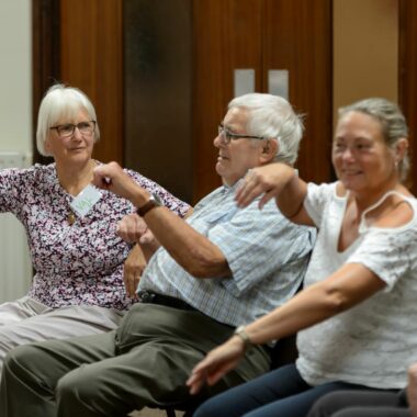 older people seated and moving their arms