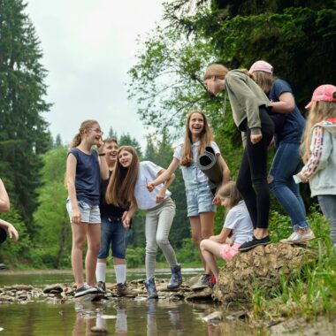 Group of children near a pond smiling