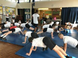 children on all fours on gym matts in school hall