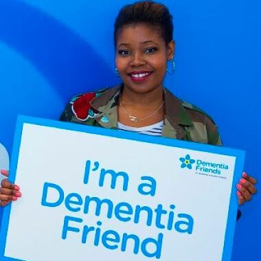 lady holding up a sign saying 'I'm a dementia friend'