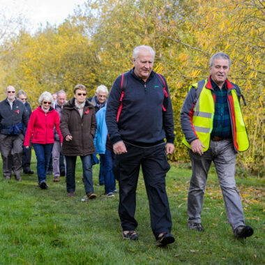 group of people walking along wooded path