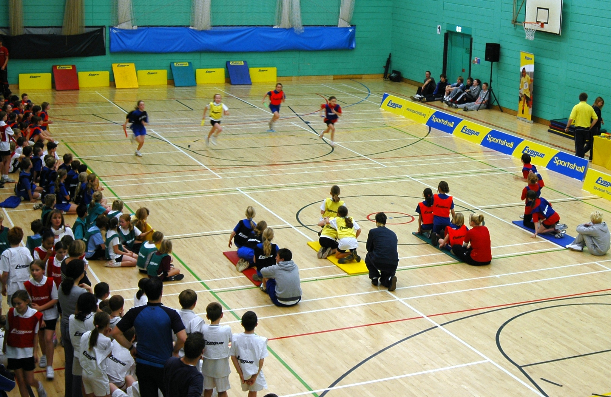 Children taking part in relay activity in a sports hall