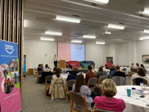 Group of people sat in a room listening to a presentation