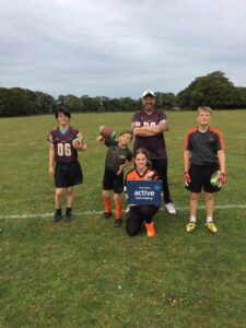 Group of young people smiling holding american football