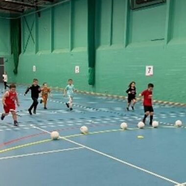 children playing football in a sports hall