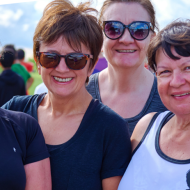 four smiling women looking hot and sweaty outside