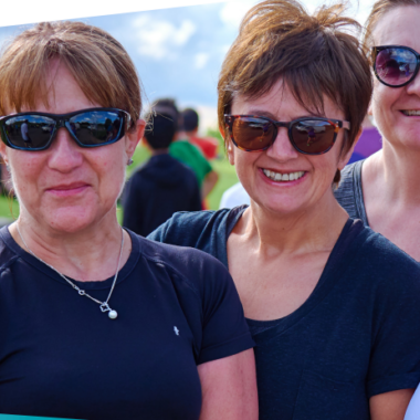 four smiling women looking hot and sweaty outside