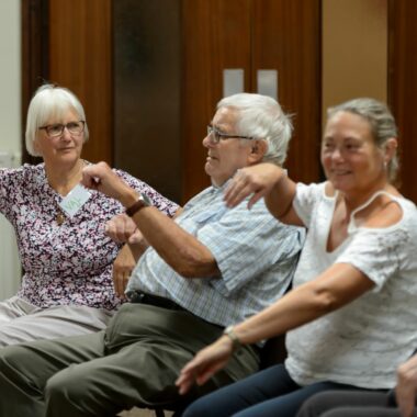 older people seated and moving their arms