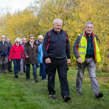 group of people walking along wooded path