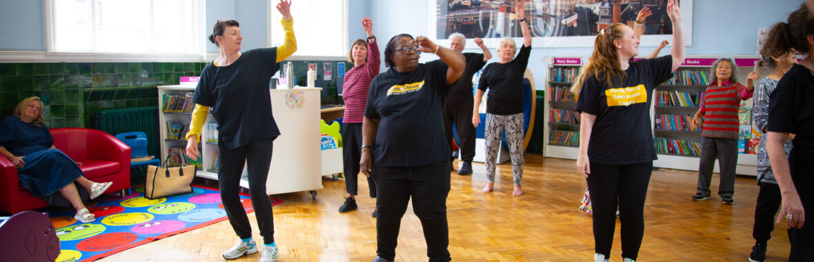 Group of people in a library taking part in a dance session