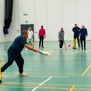 group of people playing walking cricket in sports hall