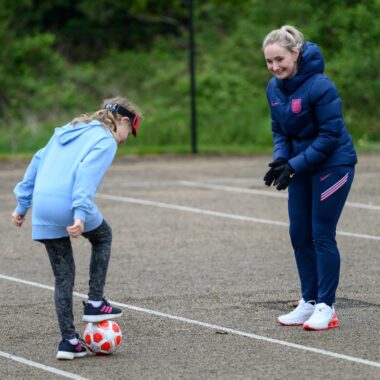 coach with a young person playing football