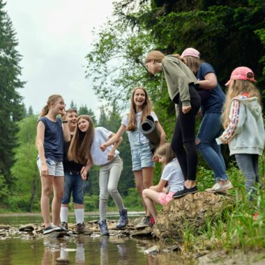 Group of children near a pond smiling