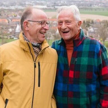 two men standing in a park smiling