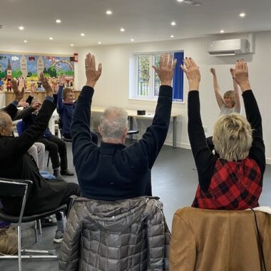 people sat with their hands in the air doing exercises