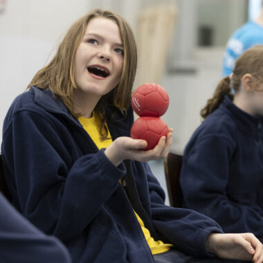 Young person holding boccia balls