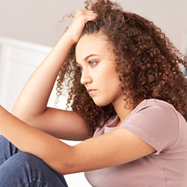 Young person sat with phone in their hand