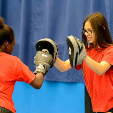 two young people boxing in a sports hall