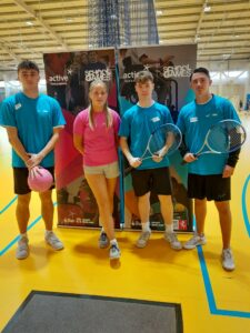 four young leaders standing in a sports hall
