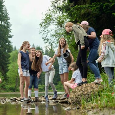 Group of children near a pond smiling