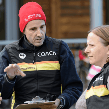 Coach chatting with two volunteers