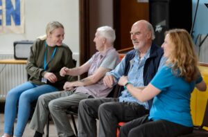 two men sitting in group doing seated exercises
