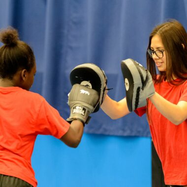 two young people boxing in a sports hall